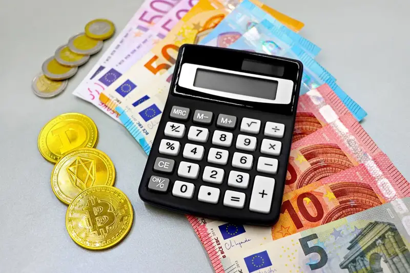 Una calculadora sobre billetes y monedas de €, junto a monedas de Bitcoin y otras criptomonedas.