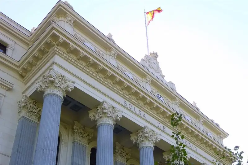 Fachada del Palacio de la Bolsa de Madrid, con sus columnas corintias y la bandera de España.