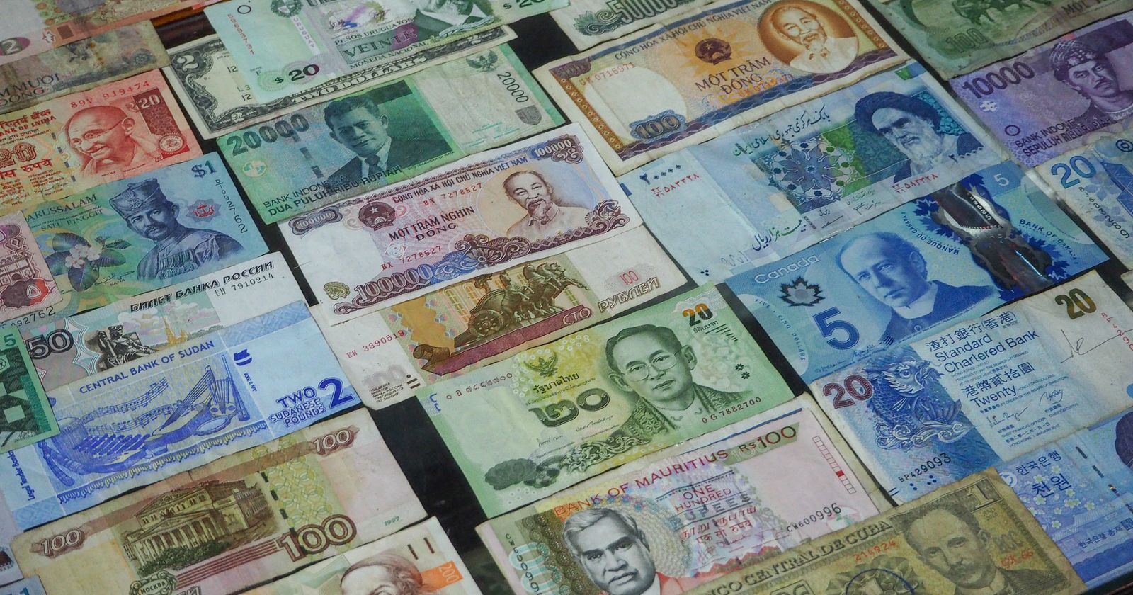 Billetes de distintas monedas del mundo ordenados en una cuadrícula